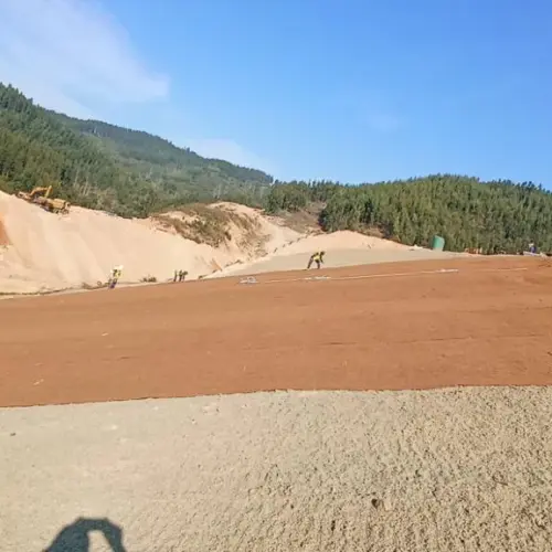 Sand and Dust Control banner coir erosion control blanket laid across an exposed sandy earthworks site for dust control